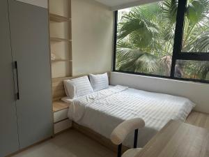 a small bedroom with a bed and a window at Hue Oi 5 Homestay - Spacious 2-Bedroom Apartment with Balcony & Pool in Hue +70 photos