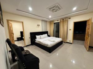 a bedroom with a bed and a couch and a chair at Pak Himalaya Hotel Kachura in Ponedas