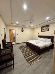 a bedroom with a bed and a couch and a chair at Pak Himalaya Hotel Kachura in Ponedas +2 photos