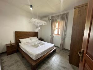 a bedroom with a bed with white sheets and a window at SAHAS Villa - Private Riverfront Garden Retreat in Beruwala in Beruwala