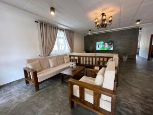a living room with a couch and a tv at SAHAS Villa - Private Riverfront Garden Retreat in Beruwala in Beruwala