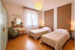 a hotel room with two beds and a chair at VIAMILANO25 in Mirandola