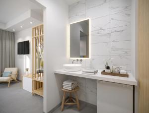a white bathroom with a sink and a mirror at Poseidon Deluxe Apartments in Kos