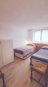 a room with two beds and a chair and two windows at Villa Clair Matin in Ax-les-Thermes