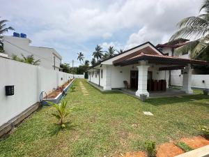 a house with a grass yard next to a building at SAHAS Villa - Private Riverfront Garden Retreat in Beruwala in Beruwala