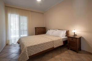 a small bedroom with a bed and a window at Avra breeze in Kriopigi