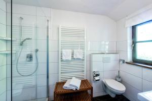 a white bathroom with a toilet and a shower at Hotelchen Schönblick in Gößweinstein +12 photos