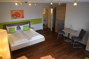 a bedroom with a bed and a table and a chair at Hotelchen Schönblick in Gößweinstein