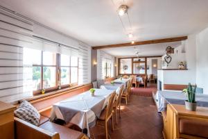 a restaurant with tables and chairs and windows at Hotelchen Schönblick in Gößweinstein