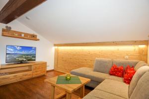 a living room with a couch and a tv at Stöcklhof in Siegsdorf