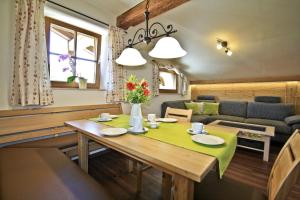 a dining room and living room with a table at Stöcklhof in Siegsdorf