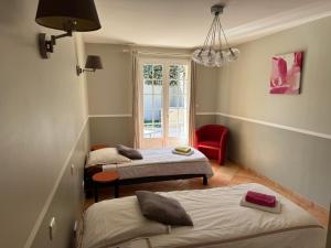 a room with three beds and a red chair at Villa Lavezzi avec piscine in Bonifacio +25 photos