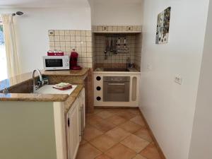 a kitchen with a sink and a stove at Villa Lavezzi avec piscine in Bonifacio