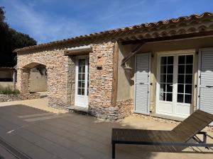 a house with white doors and a bench on a patio at Villa Lavezzi avec piscine in Bonifacio