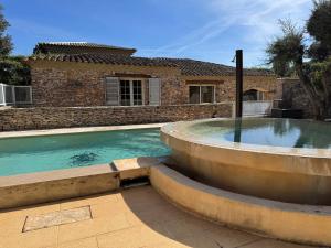a swimming pool in front of a brick house at Villa Lavezzi avec piscine in Bonifacio