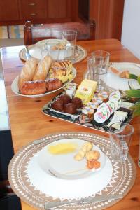 a wooden table with plates of food on it at Villa Carma in Kos