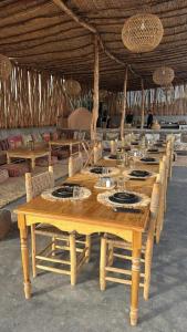 a long wooden table with plates and dishes on it at Kaha Lak in Douar Aguergour
