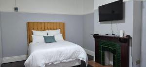 a bedroom with a bed and a tv on the wall at Relax Guest House in Goodwood
