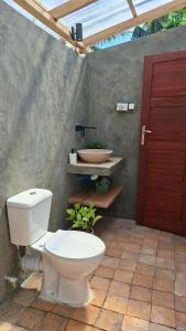 a bathroom with a toilet and a red door at Dhow Blue * Tofo Beach in Praia do Tofo +20 photos