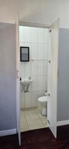 a bathroom with a toilet and a tv on the wall at Relax Guest House in Goodwood +25 photos