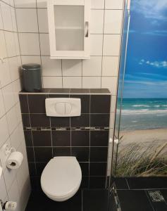a bathroom with a toilet and the beach at "Tossens Ahoi" in Tossenserdeich