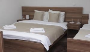 a bedroom with a large bed with white sheets and pillows at Hotel Aldi in Rožaje