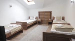 a room with three beds and a mirror at Hotel Aldi in Rožaje