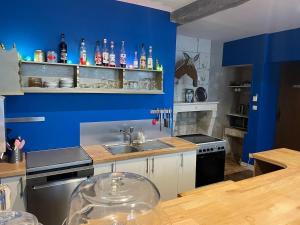 a kitchen with a sink and a blue wall at Le Bon Appart in Angoulême +8 photos