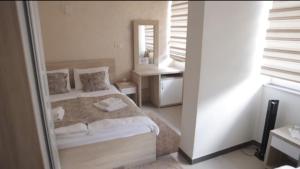 a small bedroom with a bed and a mirror at Hotel Aldi in Rožaje