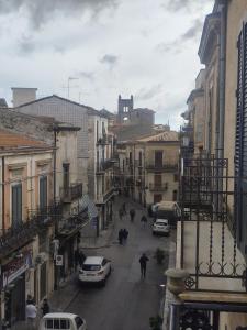 a city street with cars and people walking down the street at Le stanze del Corso in Monreale