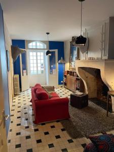 a living room with a red couch and a fireplace at Le Bon Appart in Angoulême
