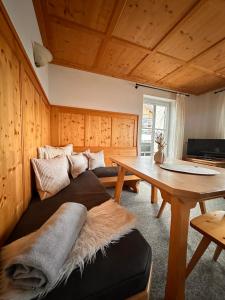 a living room with a couch and a table at Das Tannacker - Ferienwohnungen Hartmann in Fischen