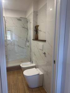 a white bathroom with a toilet and a shower at Bijoux 2 in Celano