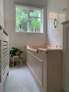 a bathroom with a pink sink and a window at Richmond Escape in Richmond upon Thames +13 photos
