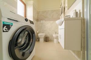 a washing machine in a bathroom with a toilet at Casa Galya with private patio by GardaDoma in Brenzone sul Garda