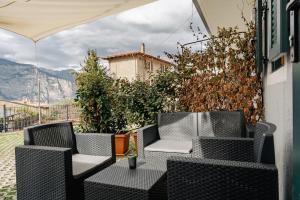 a patio with wicker chairs and a view of a mountain at Casa Galya with private patio by GardaDoma in Brenzone sul Garda +5 photos
