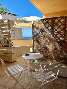 a table and two chairs and an umbrella on a patio at Arcobaleno Tropea centro in Tropea