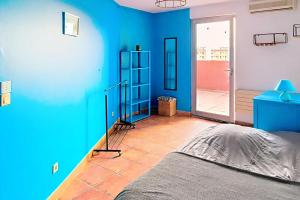 a room with a blue wall with a bed in it at Le spacieux - centre ville in Gap
