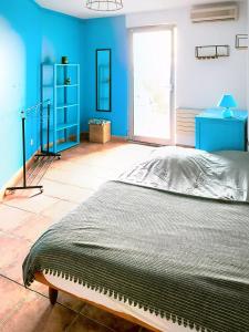 a bedroom with a bed and a blue wall at Le spacieux - centre ville in Gap +6 photos