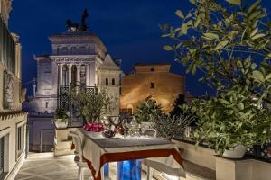 a table in a balcony with a view of a building at Domus 3 Badroom Piazza Venezia in Rome