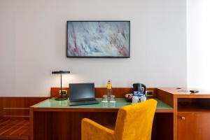 a desk with a laptop computer on top of it at voco Parma & Congressi by IHG in Parma