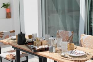 a wooden table with plates and glasses on it at Villa Helia in Kos
