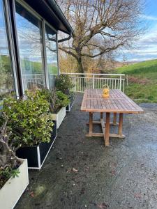 a wooden picnic table sitting outside of a building at Oxygène in Lasseube