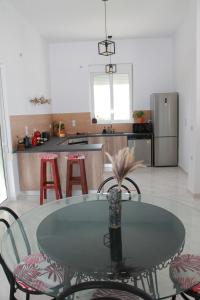 a kitchen with a glass table and stools in it at Villa Helia in Kos