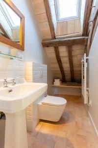 a bathroom with a white sink and a toilet at Clos Chartrain in La Chartre-sur-le-Loir +33 photos