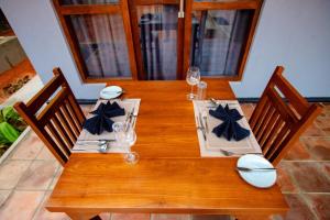 a wooden table with chairs and wine glasses on it at Viento - Habarana in Habarana