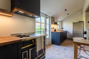 a kitchen with black cabinets and a stove top oven at Clos Chartrain in La Chartre-sur-le-Loir