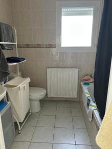 a bathroom with a toilet and a window and a sink at Oxygène in Lasseube