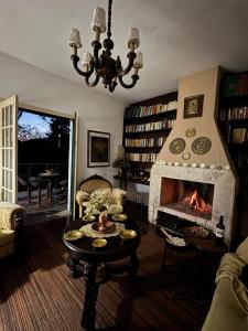 a living room with a fireplace and a couch and a table at Refúgio Pasárgada Guest House in Mairiporã