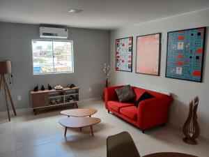 a living room with a red couch and a table at Coloft - Hospedagem e Coworking in Anápolis